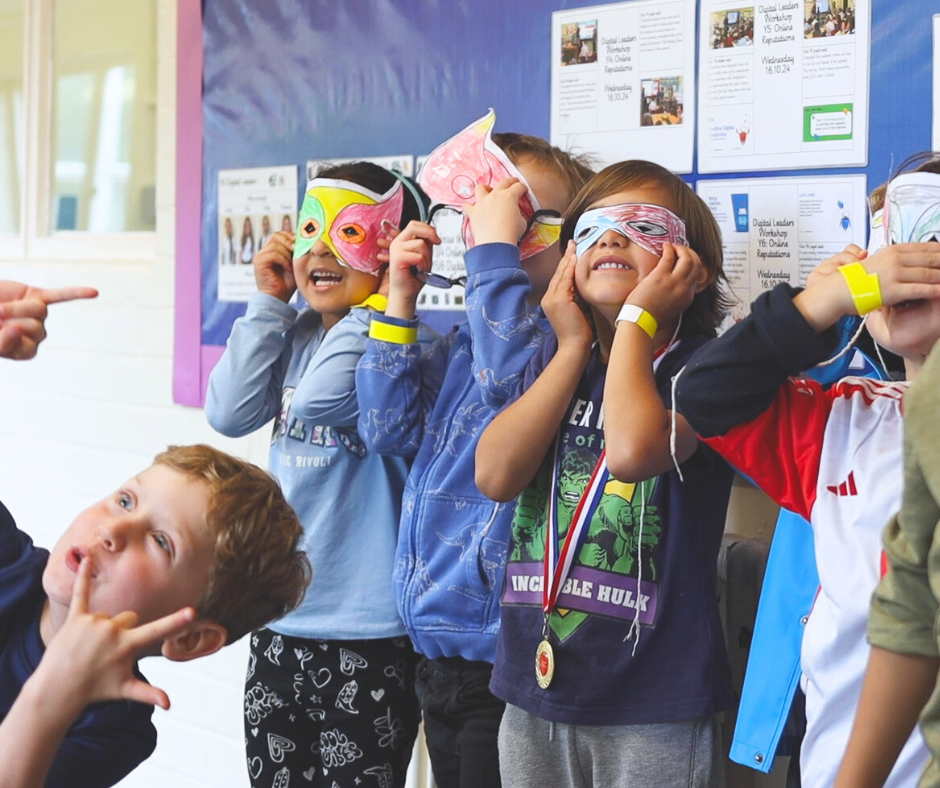 Row of children holding colourful paper masks to their face from arts & craft activities at LSC Holiday Club