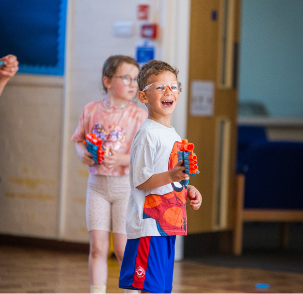 Young boy holding Nerf shooter during Nerf battles at LSC holiday club