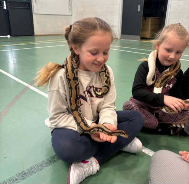 girl holding snake during animal encounters experience at LSC holiday club