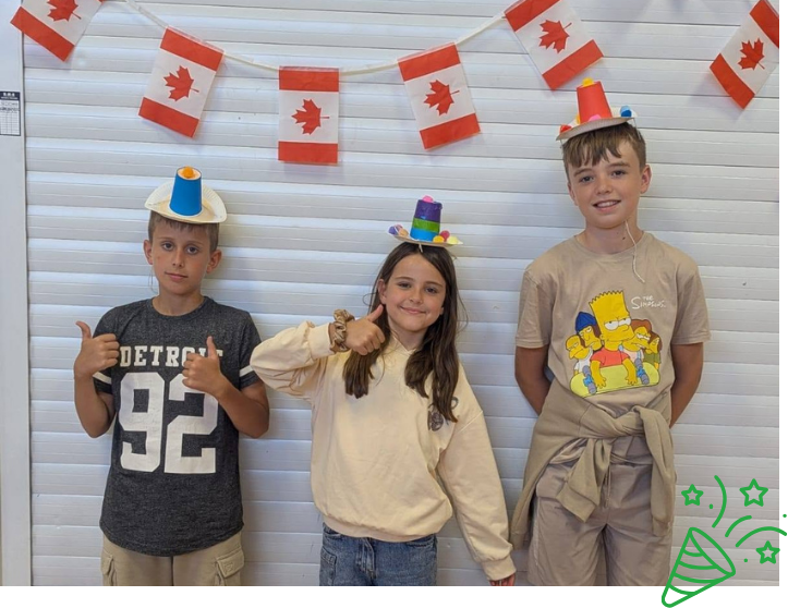 Children smiling, holding maracas they made during 'Creative' programme at LSC summer holiday club.