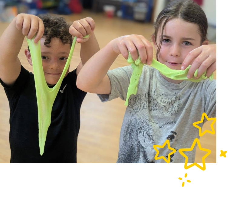 Two children holding dripping slime made during cognitive programme at LSC holiday club.