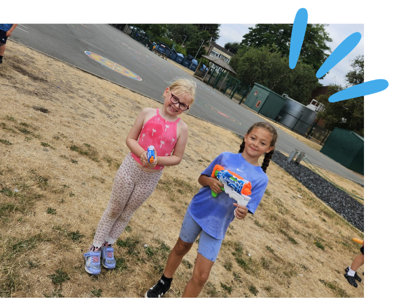 Two girls holding water pistols during Wet Wednesday Activity