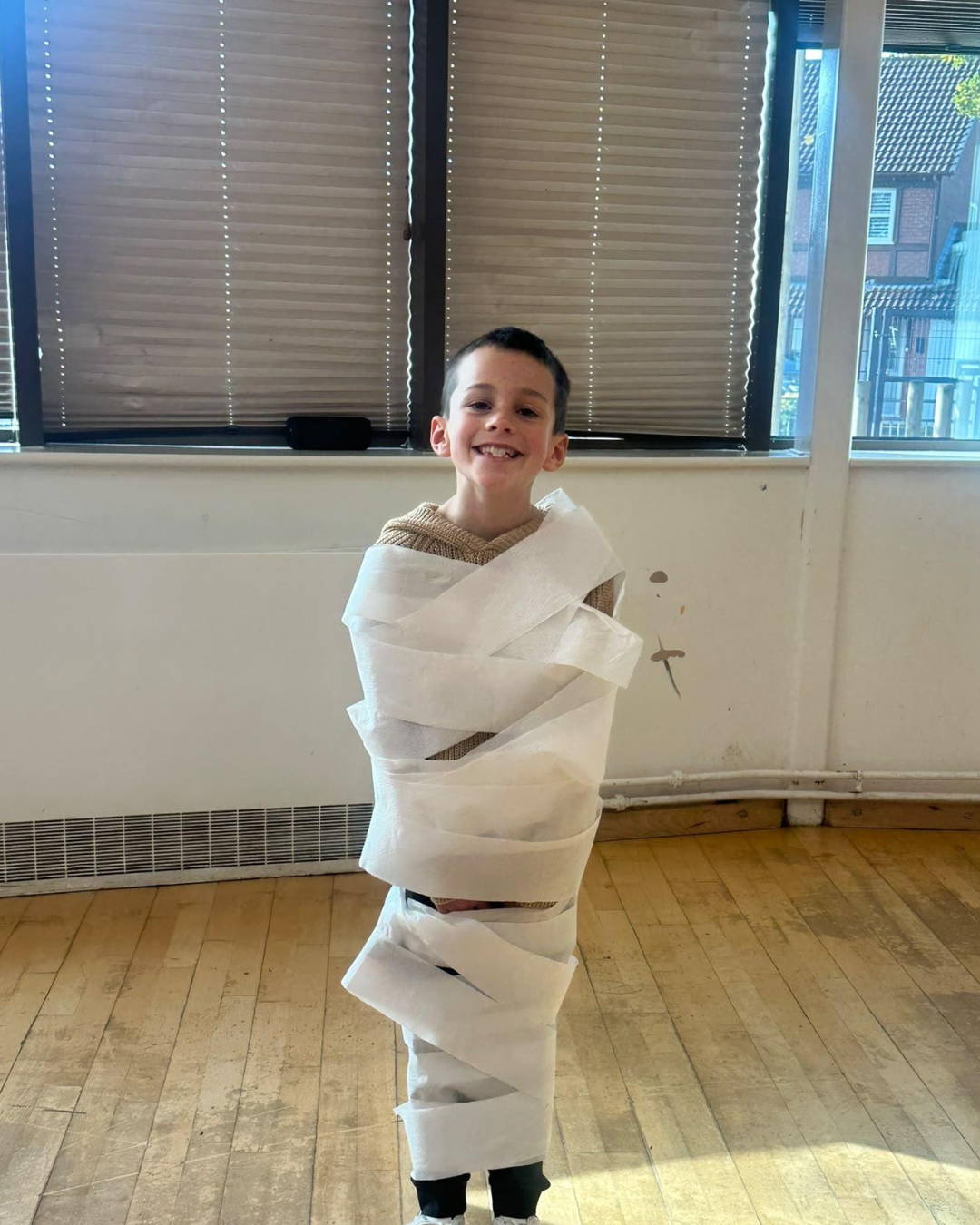 Child dressed as a mummy during a Halloween holiday club challenge