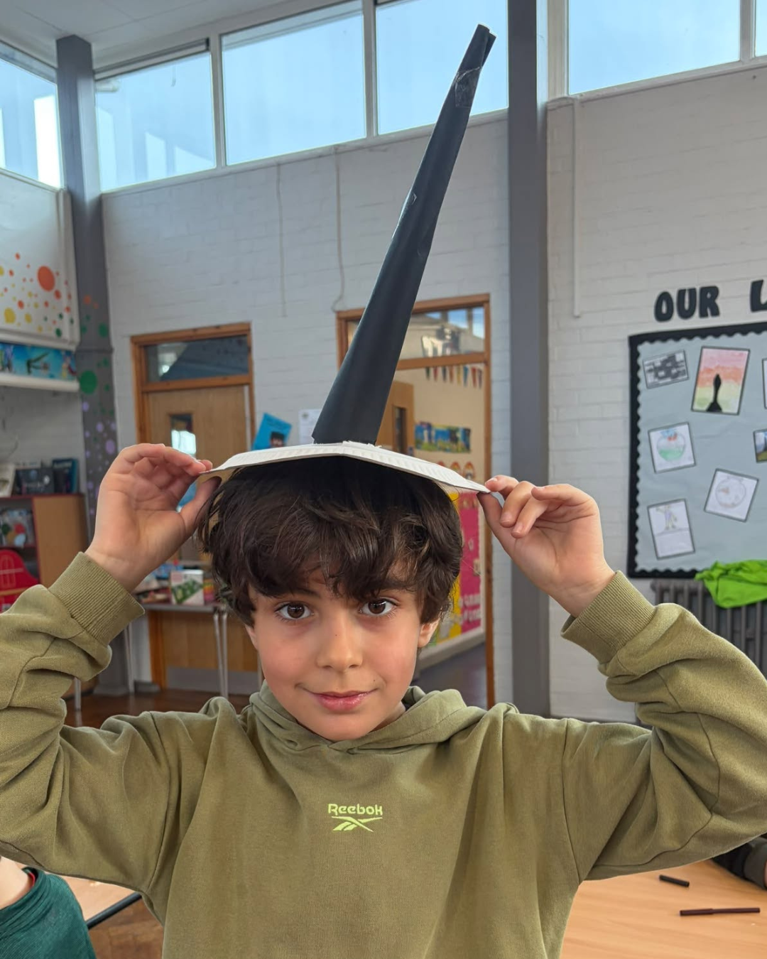 Child wearing a witch hat made during a creative holiday club session