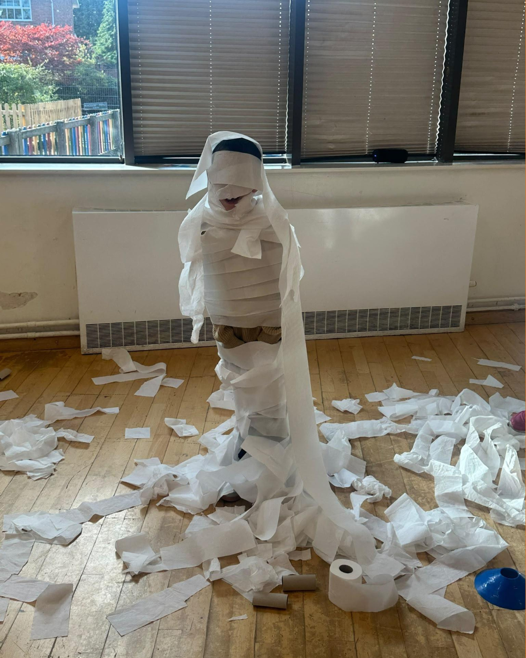 Children taking part in messy toilet paper mummy races