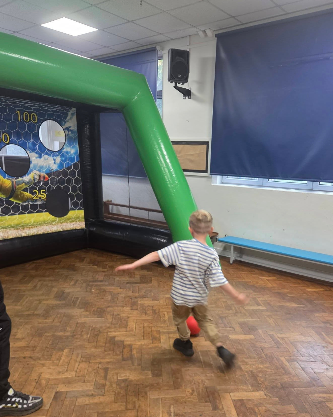 Child kicking a ball into an inflatable football game